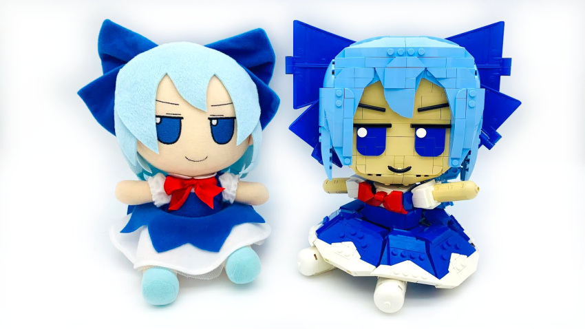1girl blue_bow blue_dress blue_eyes blue_hair bow bowtie cirno closed_mouth commentary dress english_commentary frilled_sleeves frills full_body fumo_(doll) hair_bow highres lavishlump lego lego_(medium) looking_at_viewer no_humans pinafore_dress puffy_short_sleeves puffy_sleeves red_bow red_bowtie shirt short_sleeves simple_background sleeveless sleeveless_dress solo touhou white_background white_shirt