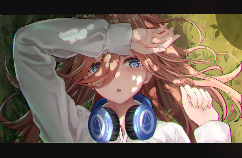 1girl :o arm_up blue_eyes brown_hair casual clenched_hand commentary_request dappled_sunlight day eyelashes fingernails go-toubun_no_hanayome grass hair_between_eyes hair_over_one_eye hair_spread_out headphones headphones_around_neck highres light_blush long_hair long_sleeves looking_at_viewer lying nakano_miku on_back on_grass open_mouth outdoors raikun_raikun shading_eyes shirt solo straight-on sunlight white_shirt
