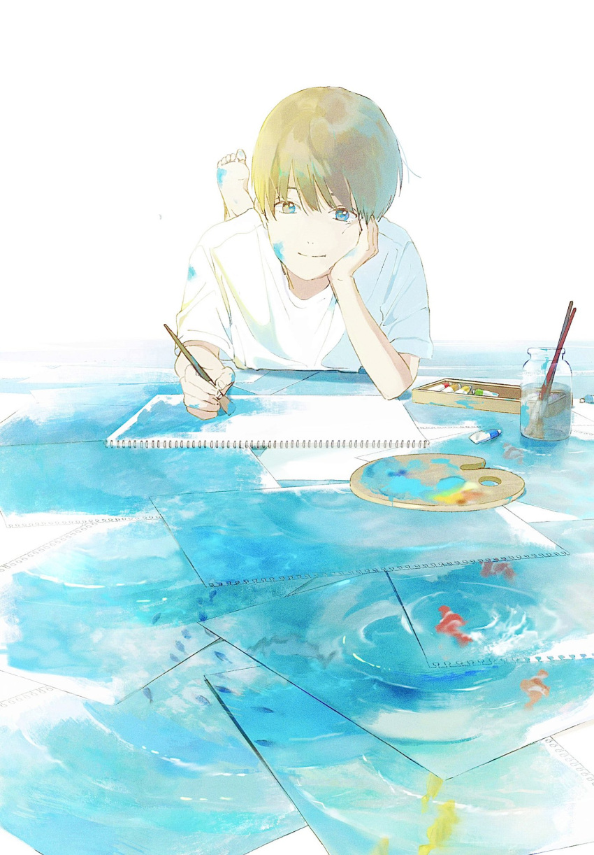 1boy barefoot blue_eyes brown_hair closed_mouth drawing fish hand_on_own_cheek hand_on_own_face highres holding holding_brush light_smile lying on_stomach original paintbrush painting_(object) paper patting picture_frame shirt short_hair short_sleeves smile solo water white_shirt yuribou