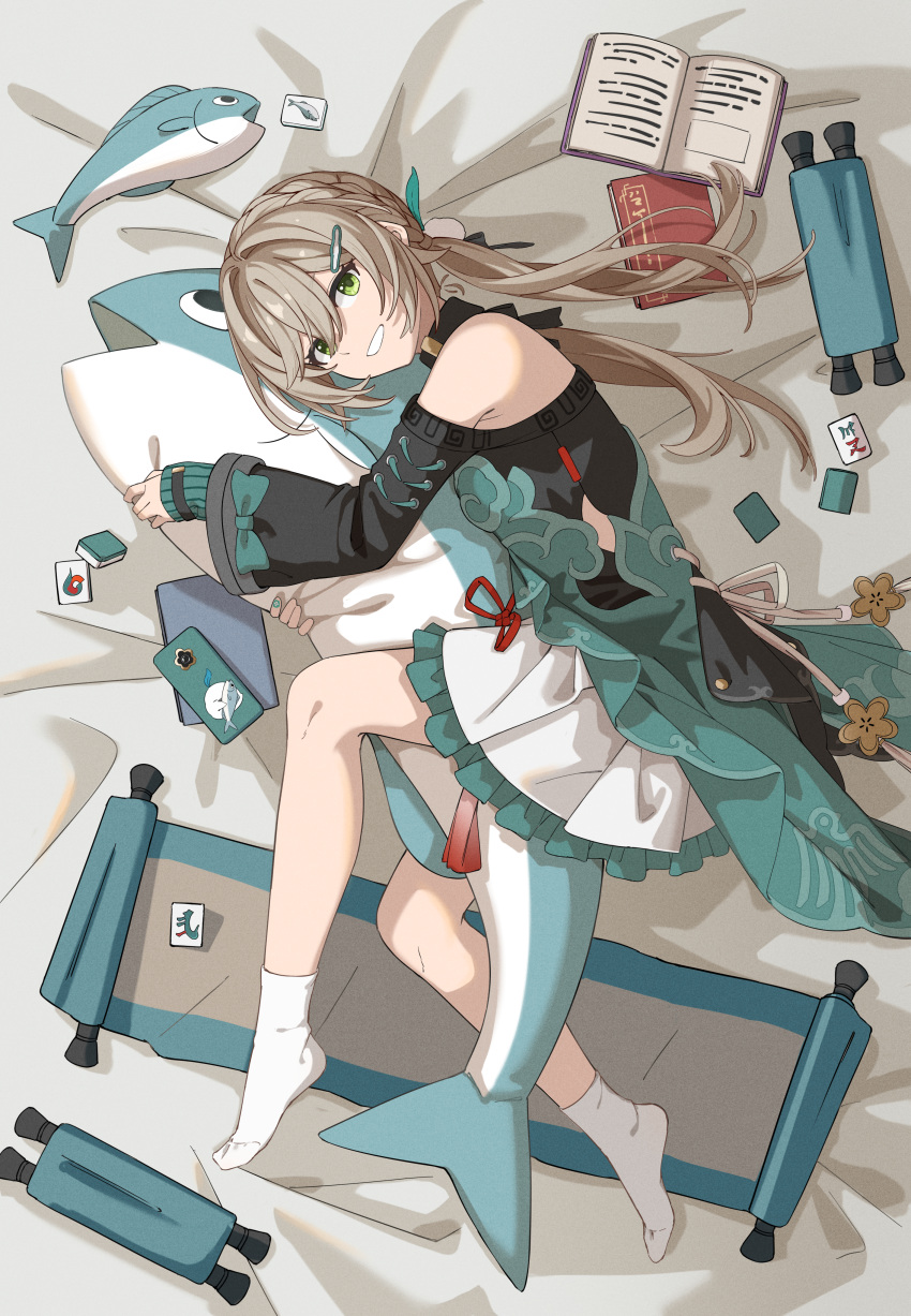 1girl absurdres bare_shoulders book cellphone clothing_cutout green_eyes grin hair_ornament hairclip highres honkai:_star_rail honkai_(series) layered_clothes light_brown_hair low_twintails lying mahjong mahjong_tile man_ge nail_polish on_bed on_side open_book phone qingque_(honkai:_star_rail) scroll shoulder_cutout skirt smartphone smile socks solo stuffed_animal stuffed_fish stuffed_toy tassel twintails white_socks wide_sleeves