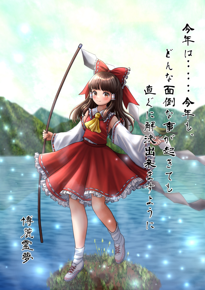 1girl arms_up ascot bare_shoulders blunt_bangs blush bobby_socks bow brown_eyes brown_hair closed_mouth commentary_request day detached_sleeves eyebrows_hidden_by_hair frilled_bow frilled_hair_tubes frilled_shirt_collar frills full_body gohei hair_bow hair_tubes hakurei_reimu highres holding holding_stick island kyabekko light_particles long_hair long_sleeves looking_at_viewer mountainous_horizon outdoors petticoat red_bow red_skirt red_vest ribbon-trimmed_sleeves ribbon_trim skirt skirt_set sky smile socks solo standing standing_on_one_leg stick touhou translation_request vest water wide_sleeves yellow_ascot