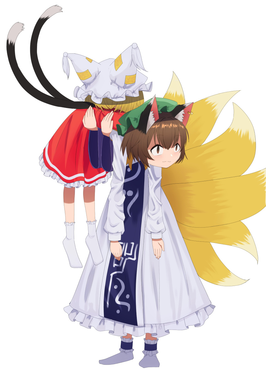 2girls absurdres animal_ear_fluff animal_ears asakura_haru blonde_hair blue_tabard brown_eyes brown_hair cat_ears cat_girl cat_tail chen closed_mouth dress earrings fox_tail frilled_dress frills full_body green_headwear hat highres jewelry long_sleeves mob_cap multiple_girls multiple_tails nekomata no_shoes print_tabard red_skirt red_vest shirt simple_background single_earring skirt skirt_set smelling smelling_clothes socks tabard tail tail_raised touhou two_tails vest white_background white_dress white_shirt white_socks white_tassel yakumo_ran