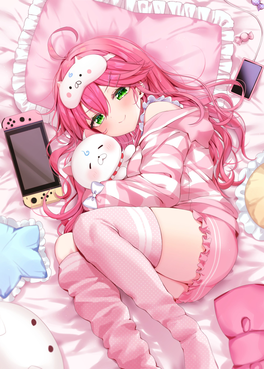 1girl absurdres candy cellphone closed_mouth food green_eyes hair_between_eyes hair_ornament hairclip highres hololive ineka_ka long_sleeves lying mask nintendo_switch phone pillow pink_hair pink_hood pink_shorts pink_thighhighs sakura_miko shirt shorts smartphone smile solo striped striped_shirt stuffed_animal stuffed_cat stuffed_toy thigh-highs virtual_youtuber