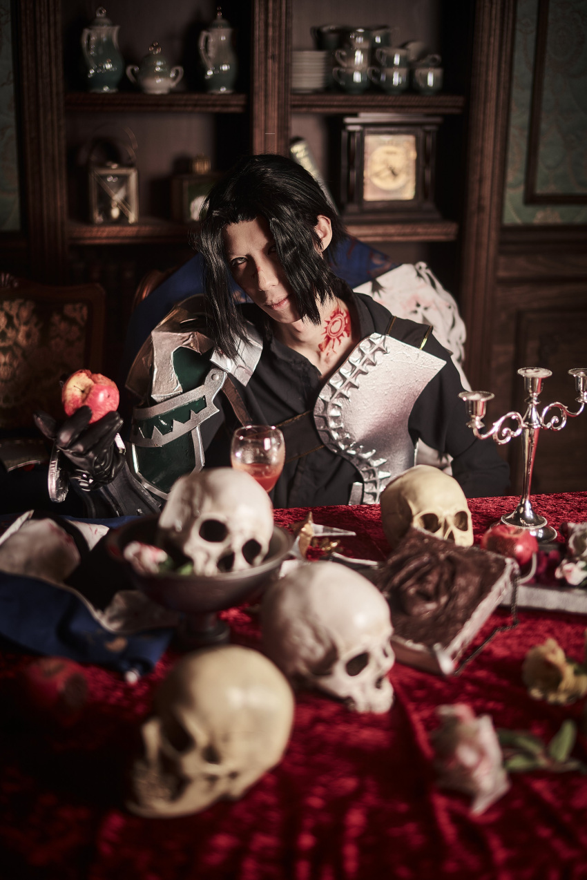 1boy absurdres apple armor black_gloves black_hair blurry blurry_background book breastplate candlestand cosplay cosplay_photo cup drinking_glass fate/grand_order fate_(series) food fruit gilles_de_rais_(saber)_(fate) gloves hair_over_one_eye highres holding holding_food holding_fruit holding_sword holding_weapon indoors looking_at_viewer male_focus neck_tattoo nori_sed pauldrons photo_(medium) prelati's_spellbook red_apple short_hair shoulder_armor single_pauldron sitting skull solo sword tattoo upper_body weapon wine_glass