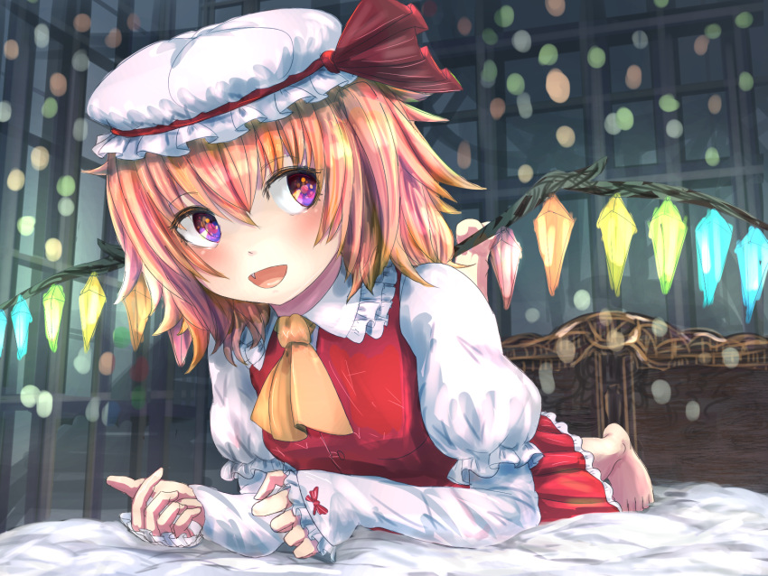 1girl adapted_costume ascot bed bed_sheet bedroom blonde_hair breasts fang flandre_scarlet frilled_sleeves frills glowing glowing_wings hair_between_eyes hat hat_ribbon highres indoors juliet_sleeves long_sleeves looking_at_viewer lying mame_(mame3737) medium_hair mob_cap multicolored_wings on_bed on_stomach open_mouth puffy_sleeves red_ribbon red_skirt red_vest ribbon shirt skirt sleeves_past_wrists small_breasts solo touhou vest violet_eyes white_headwear white_shirt wings yellow_ascot