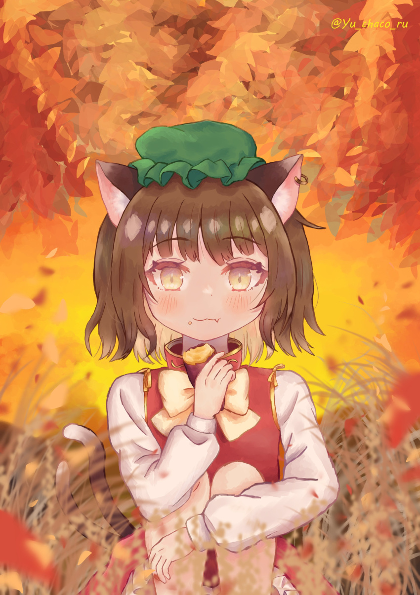 1girl :3 absurdres animal_ear_piercing animal_ears artist_name blurry blurry_foreground brown_eyes brown_hair cat_ears cat_tail chen closed_mouth commentary_request depth_of_field earrings fang fang_out food food_on_face frills gold_trim green_headwear hand_up hat highres holding holding_food jewelry knees_to_chest leaf leaf_background light_smile long_sleeves looking_at_viewer mob_cap multiple_tails nekomata petticoat puffy_long_sleeves puffy_sleeves red_skirt red_vest short_hair single_earring sitting skin_fang skirt skirt_set solo sweet_potato tail touhou twitter_username two_tails vest yu_chaco_ru