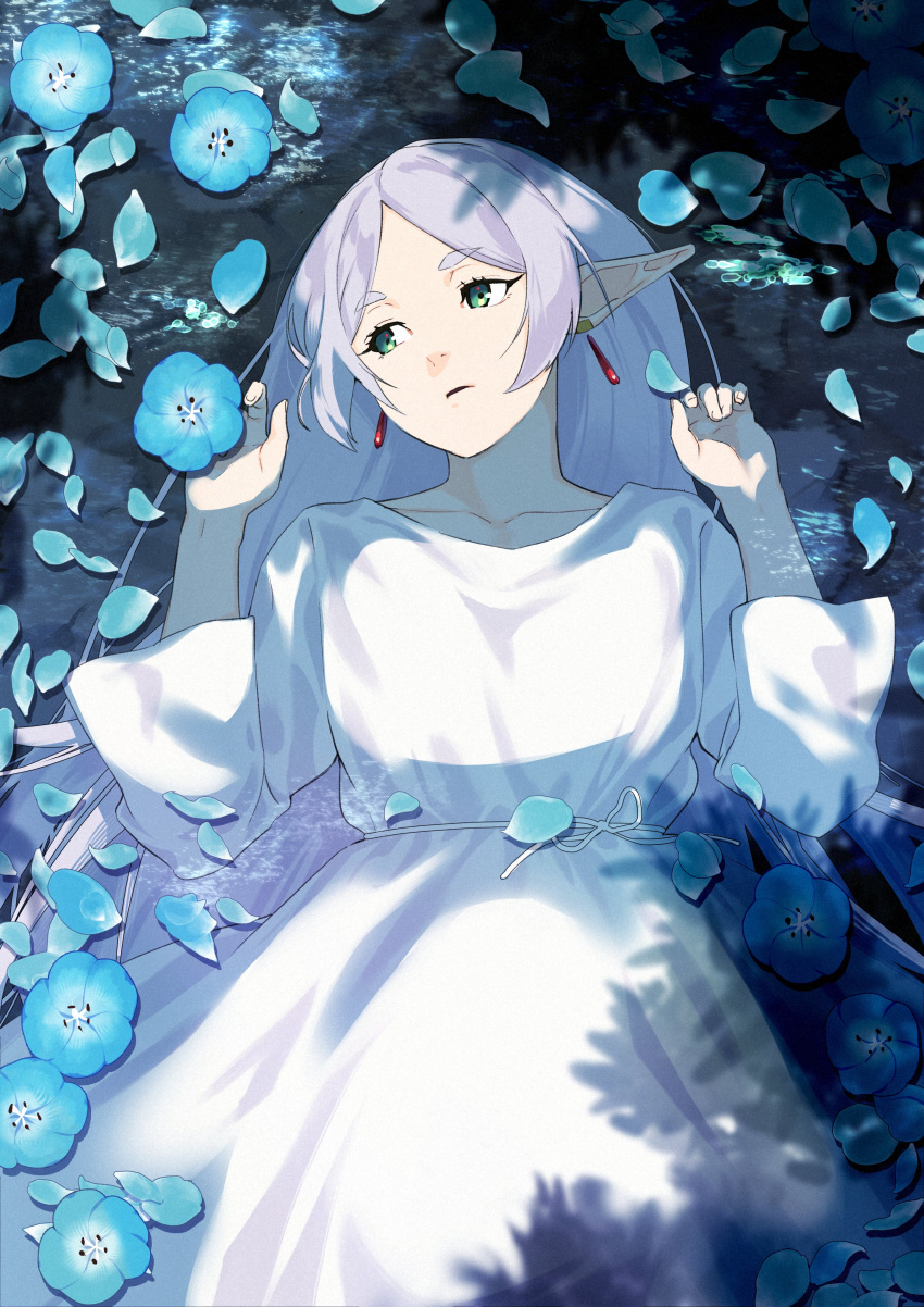 1girl absurdres afloat alternate_hairstyle blue_flower blue_petals collarbone cowboy_shot dress drop_earrings earrings elf flower flower_on_liquid frieren green_eyes hair_down hands_up highres jewelry long_hair long_sleeves looking_to_the_side lying mitsuya_ryo nemophila_(flower) nostrils on_back parted_bangs parted_lips partially_submerged petals petals_on_liquid pointy_ears short_eyebrows solo sousou_no_frieren tree_shade white_dress