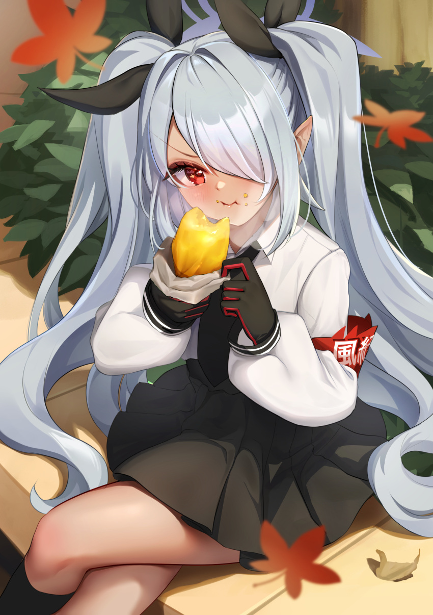 1girl absurdres black_gloves black_ribbon black_skirt blue_archive blush closed_mouth collared_shirt commentary_request eating feet_out_of_frame food food_on_face gloves grey_hair grey_halo hair_over_one_eye hair_ribbon halo highres holding holding_food iori_(blue_archive) leaf long_hair long_sleeves maple_leaf pleated_skirt pointy_ears red_eyes ribbon sakurahuji-iro shirt sitting skirt solo sweet_potato twintails white_shirt