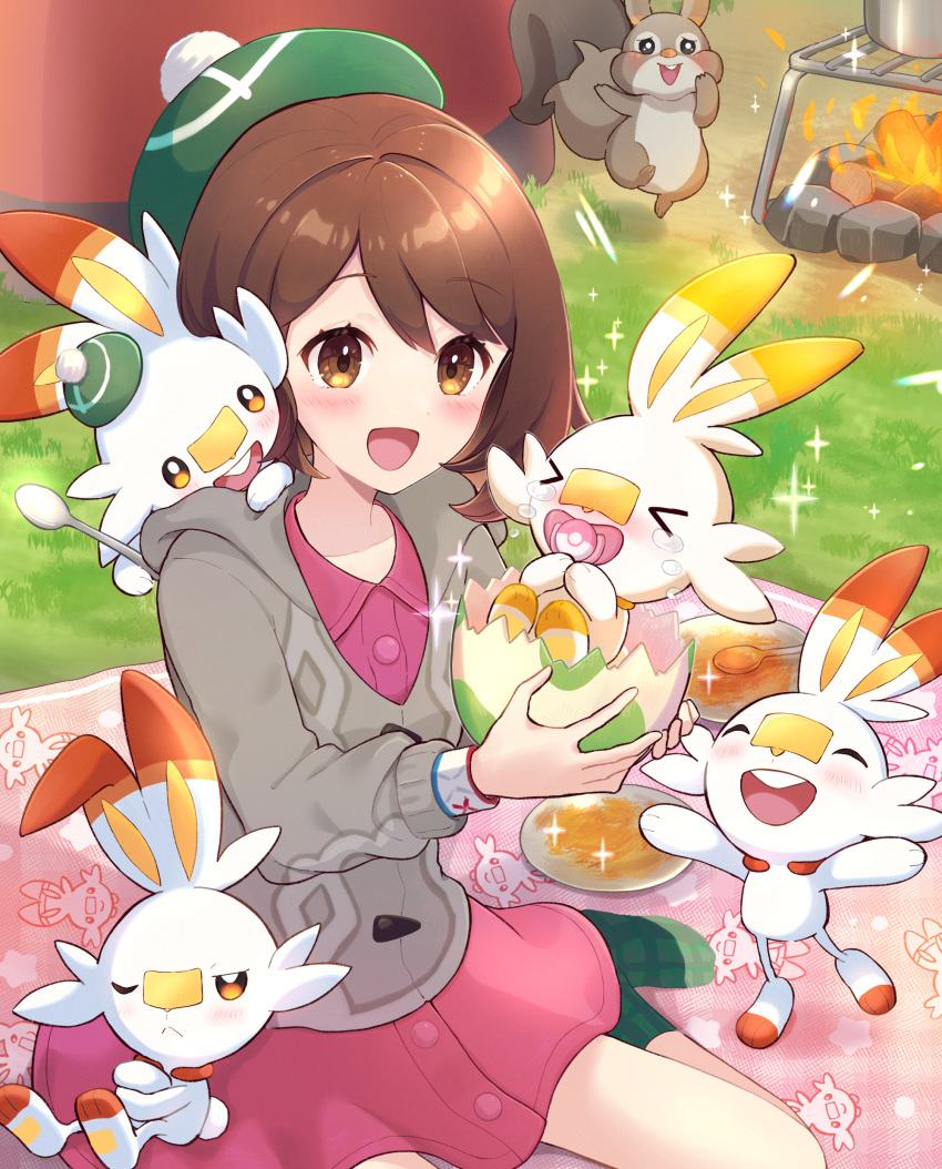 1girl :d absurdres blanket blush brown_eyes brown_hair buttons cable_knit campfire cardigan character_print collared_dress commentary_request day dress eggshell eyelashes fire gloria_(pokemon) grass green_headwear green_socks grey_cardigan haru_(haruxxe) hat highres holding hooded_cardigan open_mouth outdoors pink_dress plate pokemon pokemon_(creature) pokemon_swsh scorbunny short_hair sitting skwovet smile socks sparkle spoon tam_o'_shanter