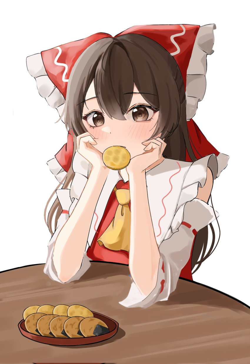 1girl ascot bow brown_eyes brown_hair cookie detached_sleeves food food_in_mouth hair_bow hakurei_reimu hands_on_own_chin head_rest highres long_hair red_bow red_shirt shirt sleeveless sleeveless_shirt solo table temmie_(temi_maru) touhou white_background yellow_ascot
