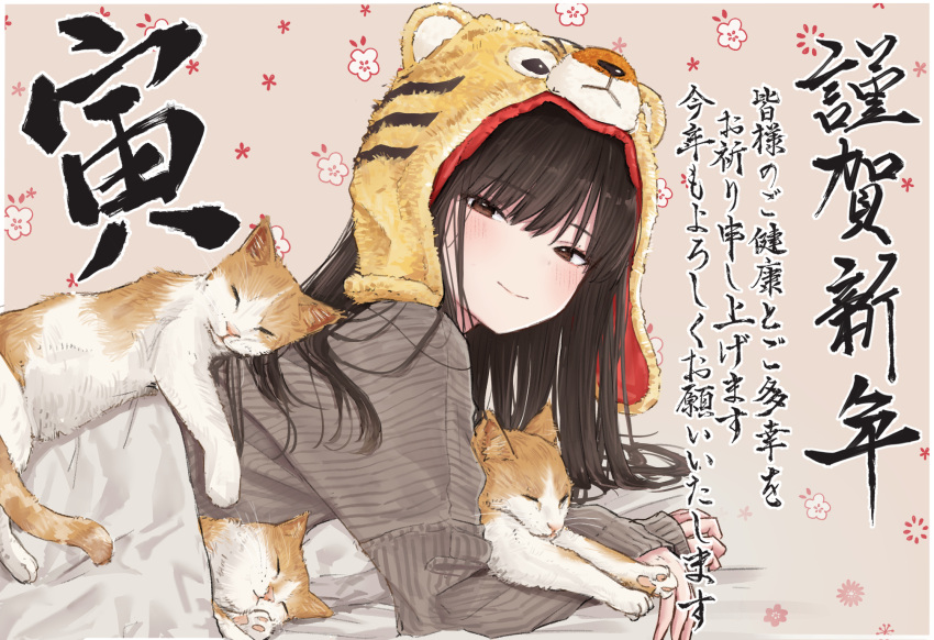 1girl akipeko animal_hood black_hair blanket blush border brown_eyes cat commentary_request floral_background grey_sweater half-closed_eyes highres hood light_smile long_hair long_sleeves looking_at_viewer lying on_stomach original outside_border pillow sleeping solo sweater tiger_hood translation_request under_covers white_border