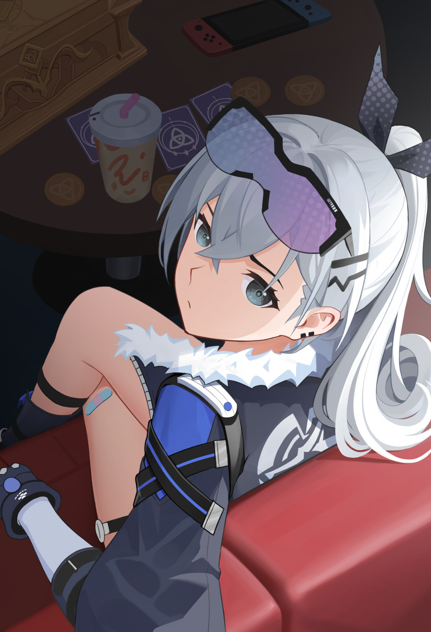 1girl absurdres bandaid bandaid_on_leg closed_mouth commentary_request couch crossed_bangs crossed_legs cup disposable_cup egert fur-trimmed_jacket fur_trim gloves goggles goggles_on_head grey_eyes grey_hair grey_jacket grey_ribbon hair_between_eyes hair_ribbon highres honkai:_star_rail honkai_(series) indoors jacket long_hair long_sleeves looking_at_viewer nintendo_switch on_couch ponytail ribbon silver_wolf_(honkai:_star_rail) sitting solo