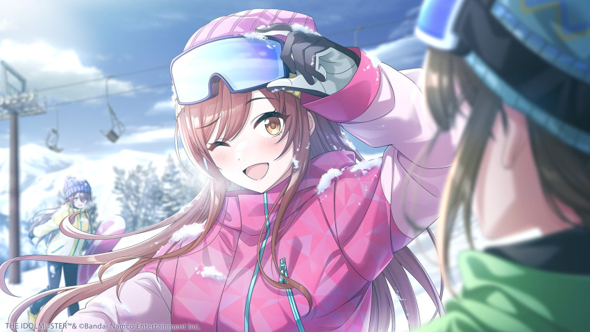 beanie blurry blurry_background brown_hair day gloves goggles goggles_on_head hat highres idolmaster idolmaster_shiny_colors idolmaster_shiny_colors_song_for_prism jacket kuwayama_chiyuki long_hair looking_at_viewer mountainous_horizon official_art one_eye_closed open_mouth osaki_amana osaki_tenka outdoors pink_jacket ski_goggles snow snowboard swept_bangs upper_body yellow_eyes