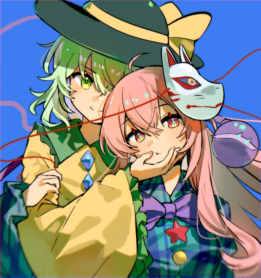 2girls black_headwear blue_background blue_shirt bow bowtie green_eyes green_hair hand_on_another's_face hata_no_kokoro height_difference highres jacket komeiji_koishi looking_at_viewer maisuiren multiple_girls pink_eyes pink_hair purple_bow purple_bowtie shirt smile touhou two-tone_shirt yellow_jacket