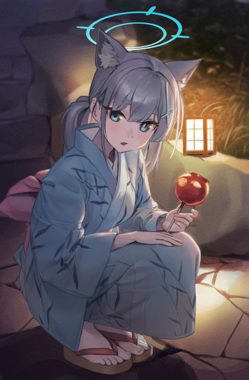 1girl absurdres animal_ear_fluff animal_ears blue_archive blue_eyes blue_halo blue_kimono blush candy_apple food grey_hair halo highres holding holding_food japanese_clothes kimono laza_(0ldsong) long_sleeves looking_at_viewer medium_hair mismatched_pupils open_mouth ponytail sandals shiroko_(blue_archive) solo squatting toes wide_sleeves wolf_ears zouri