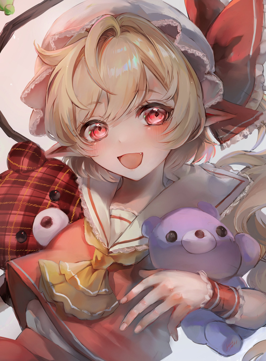 1girl absurdres ascot blonde_hair blush fang flandre_scarlet hat hibiya_saeki highres long_hair looking_at_viewer mob_cap open_mouth pointy_ears red_eyes red_skirt red_vest simple_background skirt smile solo stuffed_animal stuffed_toy teddy_bear touhou upper_body vest white_background white_headwear wrist_cuffs yellow_ascot