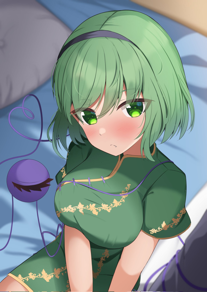 1girl alternate_costume black_hairband blurry blurry_background blush breasts bright_pupils china_dress chinese_clothes closed_mouth commentary cowboy_shot dress eyes_visible_through_hair fang from_above frown green_dress green_eyes green_hair hairband heart heart_of_string highres indoors kirisame_oreo komeiji_koishi large_breasts looking_at_viewer medium_hair short_sleeves sitting solo split_mouth swept_bangs third_eye touhou tsurime
