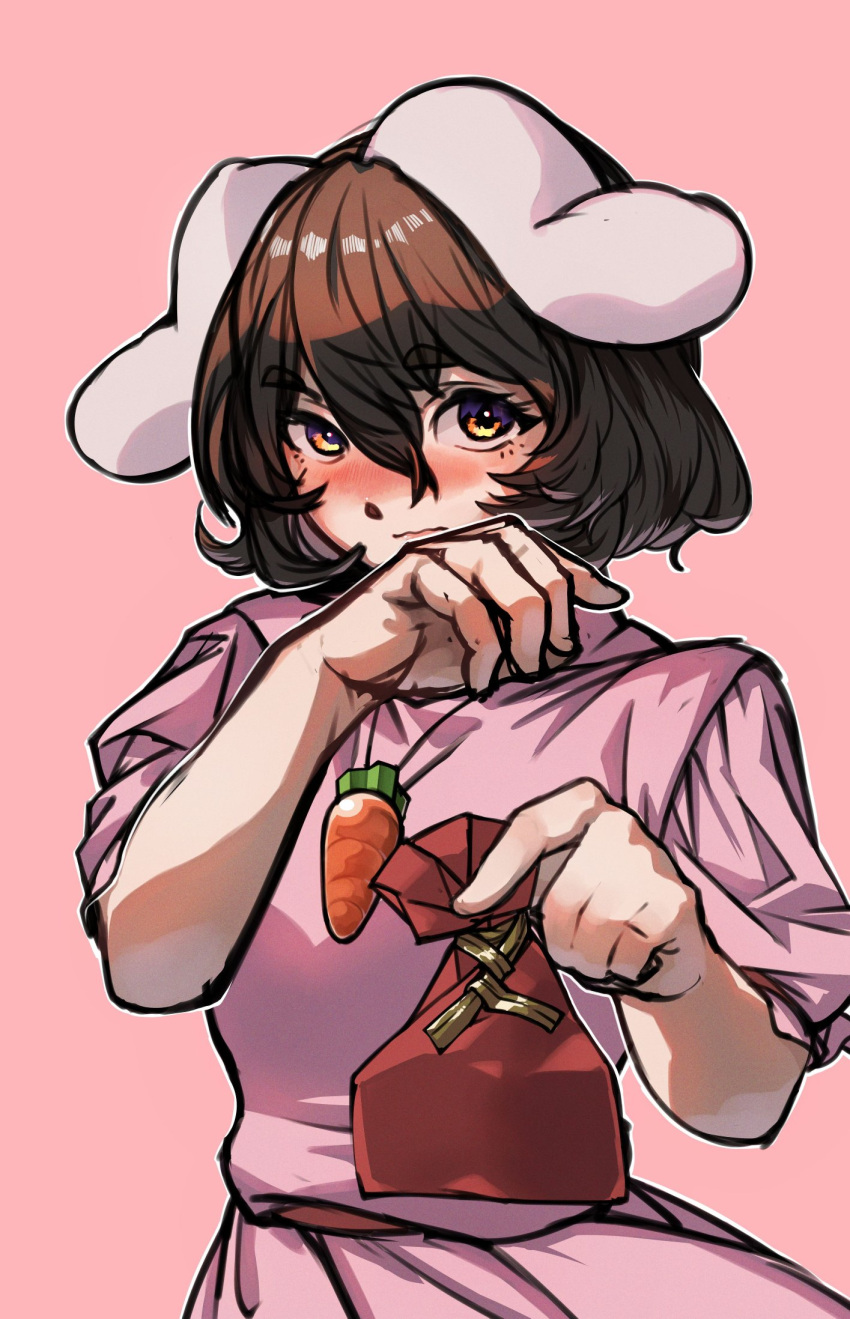 1girl animal_ears belt blush brown_eyes brown_hair carrot_necklace closed_mouth commentary_request cowboy_shot floppy_ears gift hair_between_eyes hand_up highres holding holding_gift inaba_tewi incoming_gift jewelry long_bangs looking_at_viewer necklace nio_(meple_nio) nose_blush pink_background pink_shirt pink_skirt rabbit_ears rabbit_girl red_belt shirt short_hair simple_background skirt skirt_set solo touhou