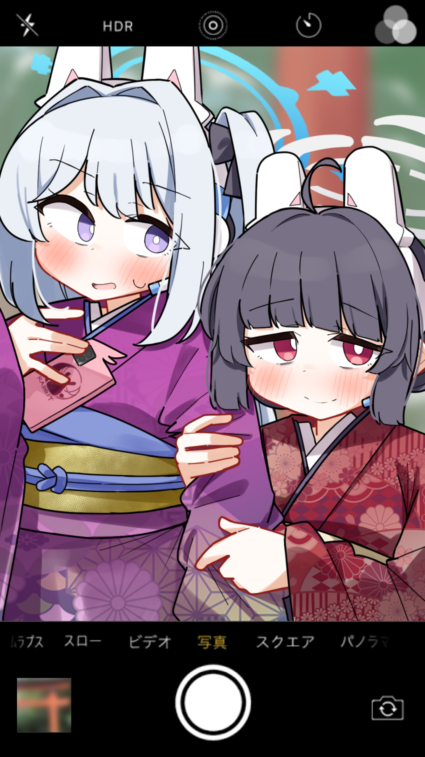 2girls ahoge arm_hug black_bow black_hair blue_archive blurry blurry_background blush bow cellphone cellphone_display closed_mouth dash_b day depth_of_field floral_print grey_hair hair_bow halo headgear headset highres japanese_clothes kimono long_sleeves miyako_(blue_archive) miyu_(blue_archive) multiple_girls obi one_side_up outdoors phone print_kimono purple_kimono red_eyes red_kimono sash sleeves_past_wrists smile sweat violet_eyes wide_sleeves