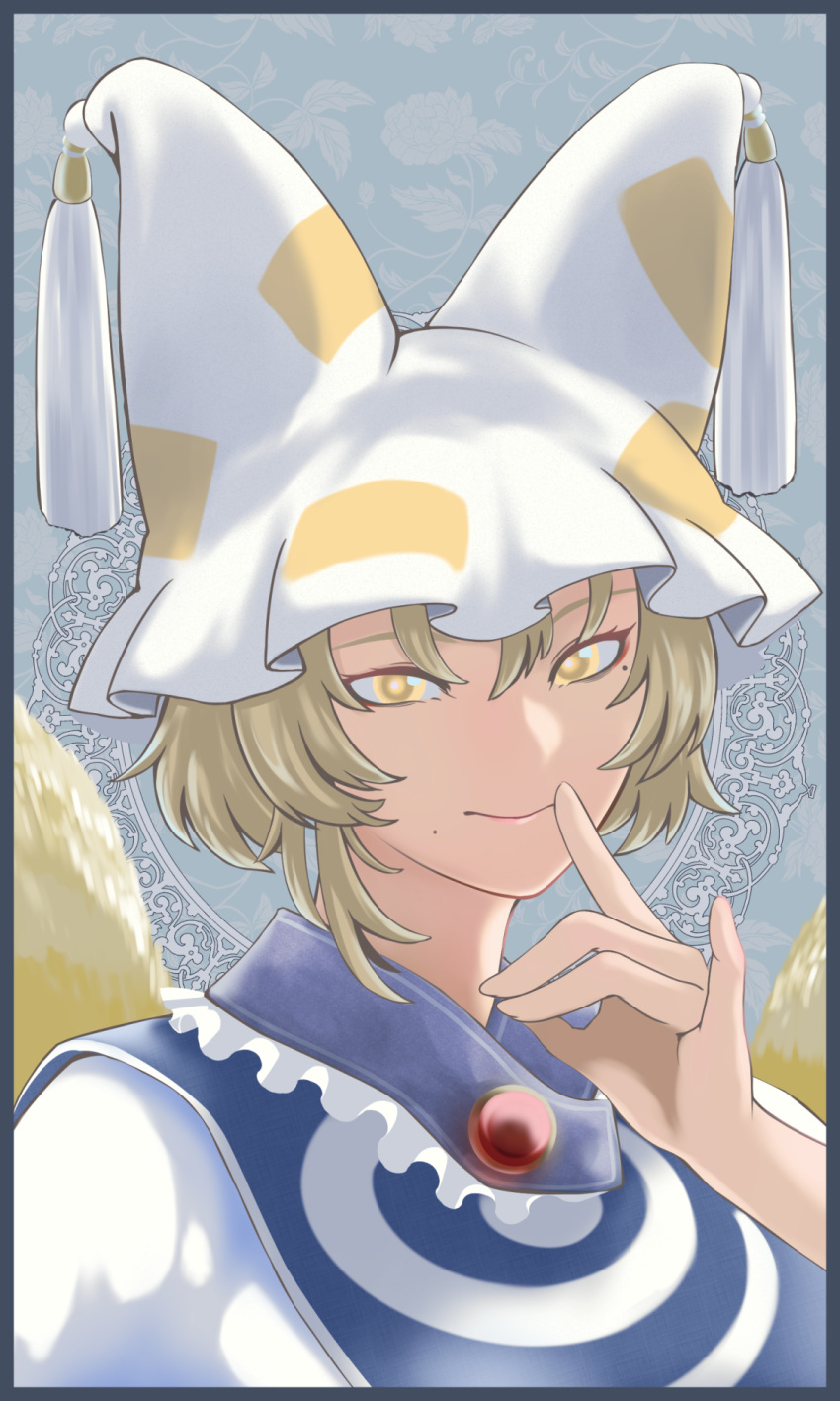 1girl animal_hat blonde_hair blue_tabard commentary_request dress floral_background fox_shadow_puppet fox_tail frilled_hat frills grey_background hair_between_eyes hand_up hat highres long_hair looking_at_viewer mob_cap mole mole_under_eye mole_under_mouth outline smile solo soretsu_nitohei tabard tail tassel touhou upper_body white_dress white_hat yakumo_ran yellow_eyes