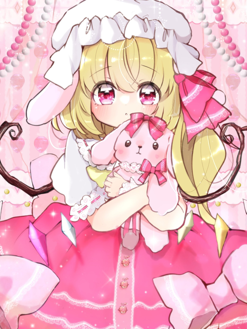 1girl animal_ears beads blonde_hair bow commentary cowboy_shot dot_nose dress dress_bow flandre_scarlet frilled_dress frilled_sleeves frilled_wrist_cuffs frills hair_bow hat highres hugging_doll hugging_object light_blush long_hair looking_at_viewer loose_hair_strand lop_rabbit_ears mob_cap ol07469724 open_mouth pink_background pink_dress pink_eyes pink_theme puffy_short_sleeves puffy_sleeves rabbit_ears short_sleeves side_ponytail solo stuffed_animal stuffed_rabbit stuffed_toy tareme touhou white_sleeves white_wrist_cuffs wings wrist_cuffs