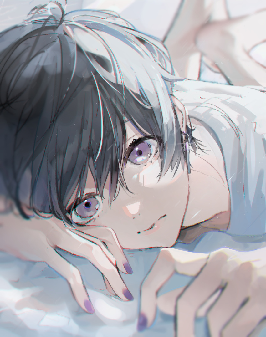 1boy barefoot bishounen black_hair blurry closed_mouth dangle_earrings depth_of_field earrings expressionless highres jewelry looking_at_viewer lying male_focus nail_polish on_stomach original purple_nails sai_gumi shirt short_hair sparkle the_pose violet_eyes white_shirt