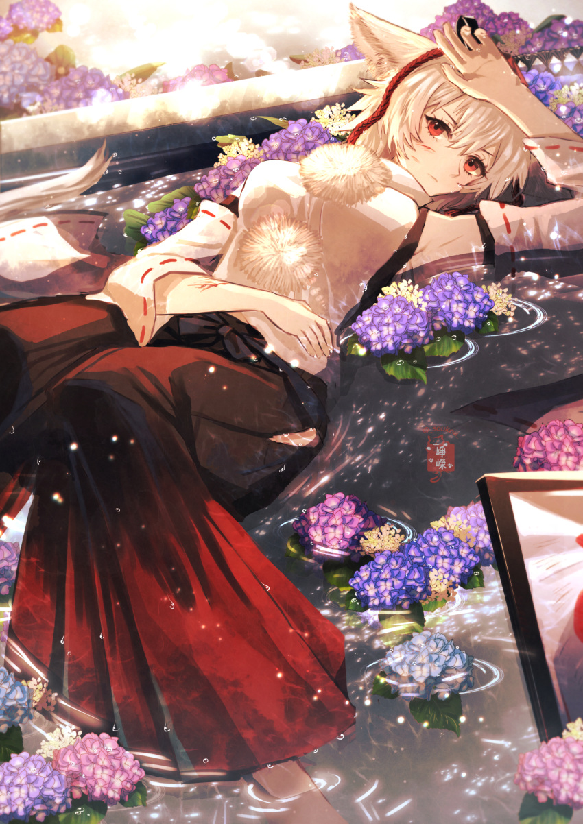1girl animal_ears arm_up artist_logo artist_name closed_mouth commentary_request detached_sleeves expressionless feet_out_of_frame flower hakama hakama_pants highres hip_vent injury inubashiri_momiji japanese_clothes looking_at_viewer lying on_back pants partially_submerged pink_flower purple_flower red_eyes red_pants ribbon-trimmed_sleeves ribbon_trim short_hair solo soukou_(artist) sword touhou water weapon wet white_hair wide_sleeves wolf_ears wolf_girl