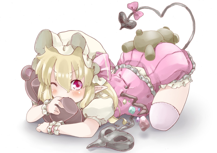 biting blonde_hair blush child flandre_scarlet hat hat_ribbon highres laevatein lying on_stomach pointy_ears red_eyes ribbon short_hair shunsuke side_ponytail simple_background solo stuffed_animal stuffed_toy tail teddy_bear top-down_bottom-up touhou white_background wings wink wrist_cuffs