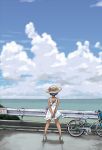  1girl arms_behind_back back bag bare_arms bare_shoulders bicycle blue_hair blue_sky clouds dress guard_rail hat hat_ribbon highres kurayami_joe ocean original ribbon road shoulder_bag sign sky sleeveless sleeveless_dress solo standing sundress tan white_dress wind 