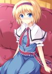  1girl alice_margatroid blonde_hair blue_dress blue_eyes blush capelet commentary_request couch dress fookun hairband highres lolita_hairband looking_at_viewer puffy_sleeves sash short_sleeves sitting smile solo touhou 