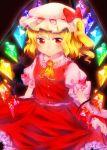  1girl ascot aura black_background blonde_hair flandre_scarlet hat hat_ribbon highres laevatein looking_at_viewer mob_cap onyuuuu puffy_short_sleeves puffy_sleeves red_eyes ribbon short_hair short_sleeves side_ponytail skirt skirt_hold skirt_set slit_pupils smile solo touhou wings wrist_cuffs 