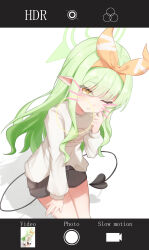  1girl ;t absurdres black_shorts blue_archive blush clenched_hand closed_mouth commentary_request cowboy_shot demon_girl demon_tail drawn_whiskers dutch_angle eyes_visible_through_hair green_hair green_halo hair_between_eyes hair_ribbon hairband halo hand_on_own_thigh hand_up highres hikari_(blue_archive) hikari_(mom's_touch)_(blue_archive) long_hair long_sleeves looking_at_viewer official_alternate_costume one_eye_closed orange_hairband orange_ribbon photo_(object) pointy_ears ribbon sakura_koigetsu shadow shorts sidelocks simple_background solo tail thick_eyebrows very_long_hair wavy_hair white_background 