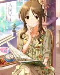  1girl book brown_hair camera chair coffee cookie cup drape food hair_ornament hand_on_own_chin idolmaster idolmaster_cinderella_girls indoors jewelry jpeg_artifacts light_smile long_hair looking_at_viewer necklace official_art ponytail saucer sitting solo sun table takamori_aiko window yellow_eyes 