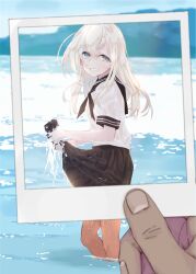  1girl 1other alakoala black_neckerchief black_sailor_collar black_skirt blonde_hair blue_eyes blush commentary_request day feet_out_of_frame grin hair_between_eyes hair_ornament highres holding holding_photo kantai_collection long_hair looking_at_viewer neckerchief outdoors photo_(object) pleated_skirt polaroid_photo pov pov_hands ro-500_(kancolle) sailor_collar school_uniform serafuku short_sleeves skirt smile solo_focus u-511_(kancolle) wading water wet wet_clothes white_hair wringing_clothes wringing_skirt 