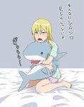  1girl alternate_hairstyle azinori123 blonde_hair blue_eyes hair_down hakodate_omiko highres hug kill_la_kill pajamas sharp_teeth solo stuffed_animal stuffed_shark stuffed_toy translated 