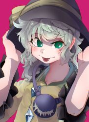  1girl :p absurdres arms_up black_hat blush bow buttons collared_shirt diamond_button frilled_shirt_collar frilled_sleeves frills green_eyes green_hair hands_on_headwear hat hat_bow highres inuyama_konan komeiji_koishi medium_hair pink_background shirt simple_background solo third_eye tongue tongue_out touhou upper_body yellow_bow yellow_shirt 