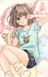  1girl antlers bedroom black_shorts blue_pillow blush brown_hair deer_print green_eyes green_shirt highres horns indie_utaite kano_(utaite) loose_socks lying mizutamako on_back one_eye_closed pillow pink_pillow polka_dot polka_dot_shorts rubbing_eyes shirt short_hair shorts simple_background socks solo stretching stuffed_animal stuffed_toy t-shirt teddy_bear utaite winking_(animated) yellow_socks 