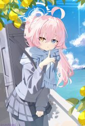  1girl absurdres ahoge bag black_thighhighs blue_archive blue_cardigan blue_eyes blush cardigan clouds cloudy_sky commentary dot_nose finger_to_face food fruit hair_between_eyes halo heterochromia highres hoshino_(blue_archive) long_hair looking_at_viewer neck_warmer orange_eyes parted_lips pink_hair shoulder_bag skirt sky solo sunlight thigh-highs tree upper_body zizhucan 
