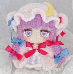  1girl amigurumi_(medium) blue_bow blush bow chibi chibi_only cloak crescent crescent_hat_ornament dress grey_background hair_bow hat hat_ornament heart heart-shaped_pupils highres long_hair looking_at_viewer mob_cap moni_monico multiple_hair_bows patchouli_knowledge photo_(medium) pink_cloak pink_hat purple_dress purple_hair red_bow symbol-shaped_pupils touhou unconventional_media violet_eyes 