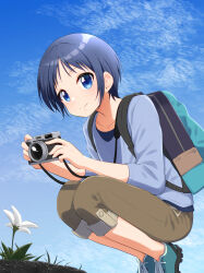  1girl backpack bag blue_eyes blue_hair blue_shirt brown_pants camera clouds commentary_request flower gomasho_asuka grass highres holding holding_camera kurosaki_honoka looking_at_viewer pants shirt smile squatting yama_no_susume 