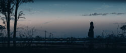  1girl absurdres blurry blurry_foreground city_lights clouds commentary dark dress dusk english_commentary gracile gradient_sky highres original power_lines reflection reflective_liquid scenery silhouette sky solo standing town tree water 