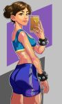  1girl absurdres alternate_hairstyle ass bangs bike_shorts breasts brown_eyes brown_hair cellphone chun-li cowboy_shot double_bun eyebrows from_behind godstime_ojinmah highres lips midriff nose parted_bangs phone self_shot smartphone solo sports_bra street_fighter street_fighter_zero studded_bracelet 