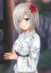  1girl blue_eyes blurry blush depth_of_field eyes_visible_through_hair fingers_together flower hair_flower hair_ornament hair_over_one_eye hairclip hamakaze_(kantai_collection) hands_together highres japanese_clothes kantai_collection kimono light_smile looking_at_viewer obi sash shokora_momiji silver_hair smile solo 