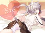  1girl :3 animal_ears bed cat_tail dated from_behind heart kantai_collection kashima_(kantai_collection) looking_at_viewer looking_back lying mouth_hold nochita_shin on_bed on_stomach panties pillow pleated_skirt purple_panties school_uniform short_hair silver_hair skirt smile tail twitter_username underwear violet_eyes 