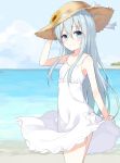  1girl alternate_costume beach blue_eyes dress flat_chest flower from_side hand_on_headwear hat hat_flower hibiki_(kantai_collection) highres huwali_(dnwls3010) kantai_collection long_hair looking_at_viewer ocean silver_hair skirt_hold sleeveless smile solo straw_hat sundress white_dress 