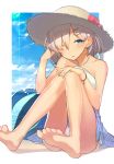  1girl :p bare_shoulders barefoot beach bikini clouds eyes_visible_through_hair feet flower hair_ornament hair_over_one_eye hairclip hamakaze_(kantai_collection) hand_in_hair hat hat_flower highres hitoshi_(hitoishi_14n2i5) kantai_collection lens_flare one_eye_closed revision silver_hair sitting sky soles solo straw_hat swimsuit toes tongue tongue_out water 