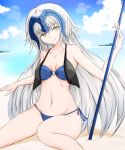  1girl beach blonde_hair breasts cleavage fate/grand_order fate_(series) groin highres jeanne_alter long_hair navel o-ring_bikini ocean ruler_(fate/apocrypha) sand side-tie_bottom smile solo summer water yellow_eyes yuki_maccha_(yukimattya10) 