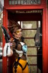  1girl ardsami bodysuit brown_hair city cosplay goggles gun leggings open_mouth outdoors overwatch phone photo short_hair smile spandex tracer_(overwatch) vest weapon 
