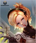  1girl :p absurdres bangs black_gloves blonde_hair blue_eyes bodysuit copyright_name emblem eyelashes gloves glowing glowing_wings hair_ornament hair_tie high_collar highres jewelry kiyomasa_ren lips lipstick logo looking_at_viewer makeup mechanical_halo mechanical_wings mercy_(overwatch) overwatch pink_lips pink_lipstick ponytail single_earring solo spread_wings tongue tongue_out turtleneck upper_body wings 