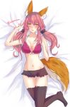  1girl animal_ears bed black_legwear blush bra breasts cleavage fate/extra fate_(series) fox_ears fox_tail groin hand_on_own_chest highres large_breasts looking_at_viewer lying midriff navel open_mouth pink_bra pink_hair solo tail tamamo_(fate)_(all) tamamo_no_mae_(fate) tanaji twintails twitter_username underwear yellow_eyes 